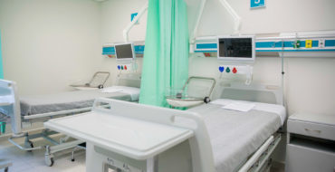 Photo of a hospital room with two beds, both empty
