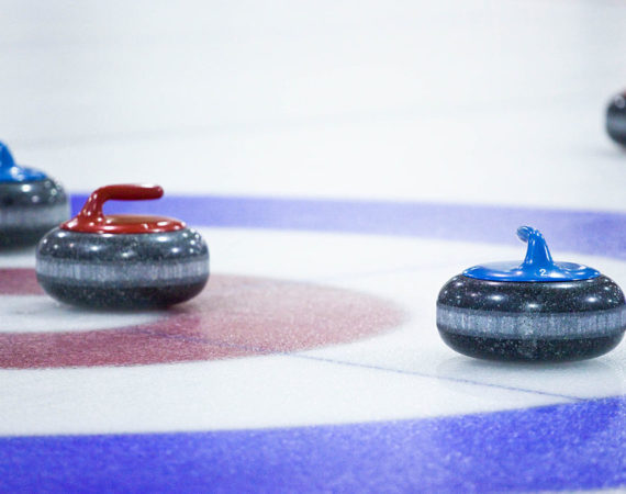 4 curling pucks on circle targets in the ice