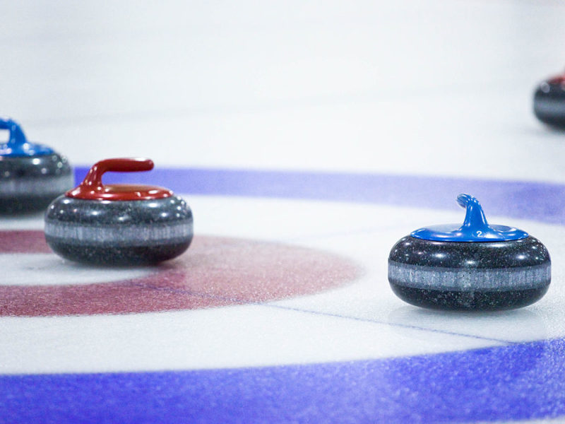 4 curling pucks on circle targets in the ice