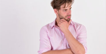 Man stoking chin thoughtfully while looking off camera