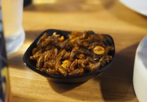 A small bowl of fried crickets on a restaurant table