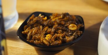 A small bowl of fried crickets on a restaurant table
