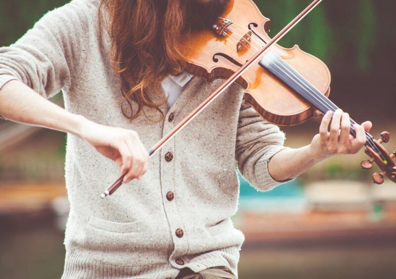 a woman playing a violin, her face isn't visible