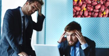 two young men in business suits looking at a computer and rubbing their foreheads in dismay. Inset in the upper right corner is a photo of red beans with sparkles.