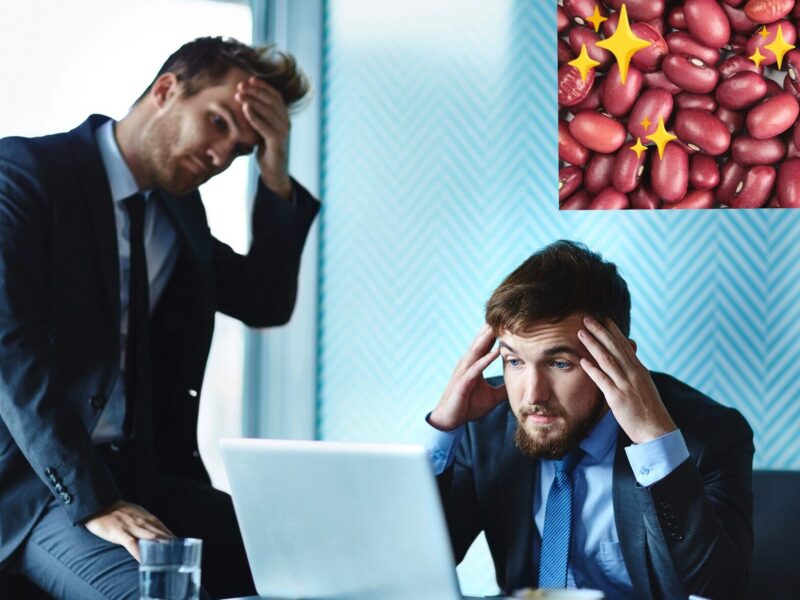 two young men in business suits looking at a computer and rubbing their foreheads in dismay. Inset in the upper right corner is a photo of red beans with sparkles.