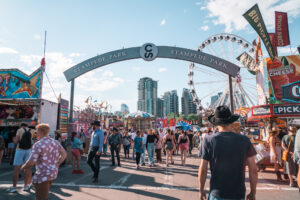 Crowds of people enter Stampede Park, the midway carnival rides and games area