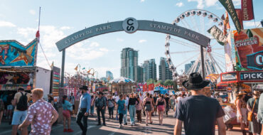Crowds of people enter Stampede Park, the midway carnival rides and games area