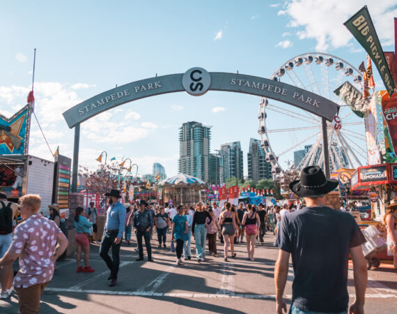 Crowds of people enter Stampede Park, the midway carnival rides and games area