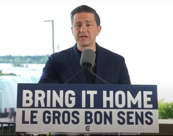 Pierre Poilievre standing at a lectern behind a sign that says "Bring It Home/Le Gros Bon Sens"